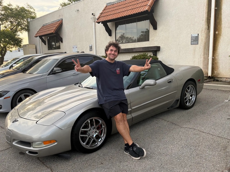 Michael R. leaning on his silver C5 Corvette convertible