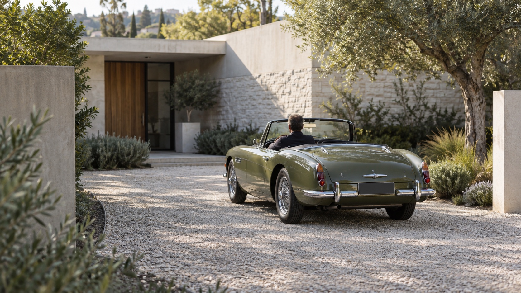 An olive green roadster in a quiet residential driveway