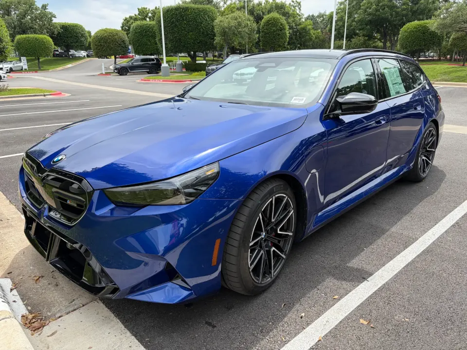 Blue BMW M5 Touring in a parking lot