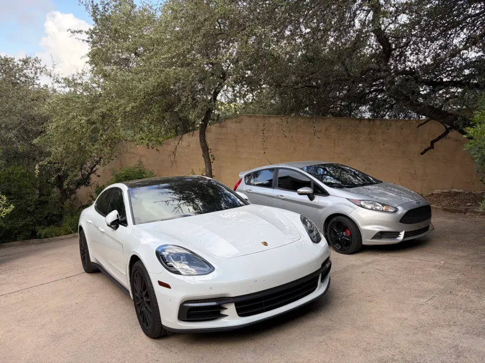 White Porsche Panamera and silver Ford Fiesta ST in a driveway